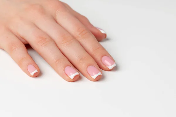 Beautiful female palm with french manicure on white — Stock Photo, Image