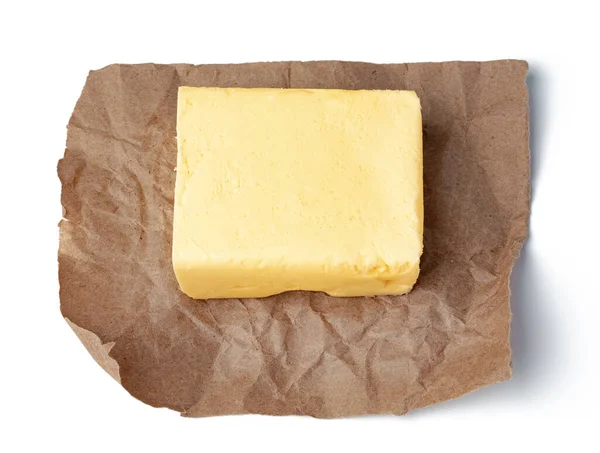 Mantequilla fresca sobre papel artesanal aislado sobre fondo blanco — Foto de Stock