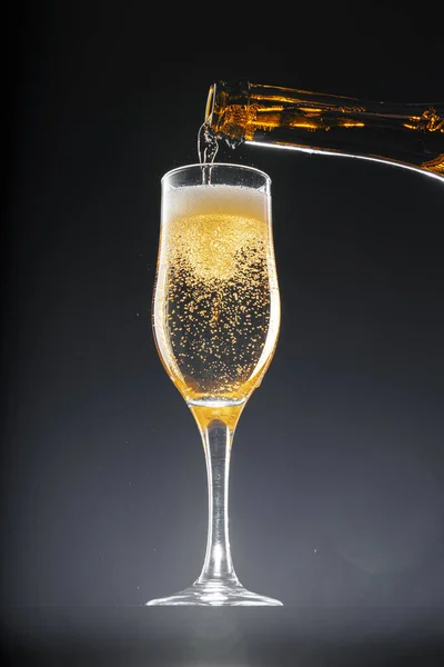 Champagne versando in vetro su sfondo nero — Foto Stock