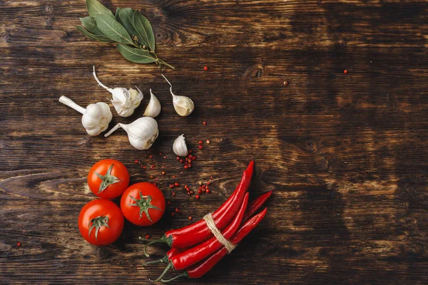 Hvitløk og chili-pepper på mørkt trebord – stockfoto