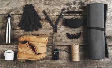 Grunge ahşap arka planda çeşitli yürüyüş ekipmanı araçlarının üst görünümü