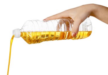 Plastik şişeden yemek yağı döken bir kadın eli. Beyaz arkaplanda izole.