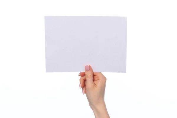 Female hand holding blank white sheet of paper isolated on white — Stock Photo, Image