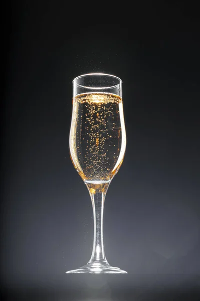 Copo cheio de champanhe sobre fundo preto — Fotografia de Stock