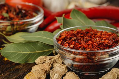 Cam kasede kırmızı acı biber ve koyu renkli otlar.