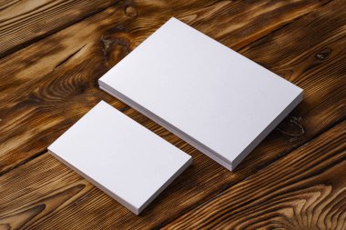 Kahverengi ahşap arka planda beyaz kartvizit yığını