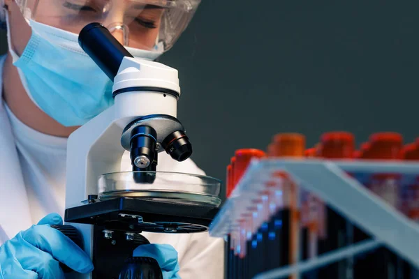 Femme scientifique regardant à travers un microscope en laboratoire — Photo