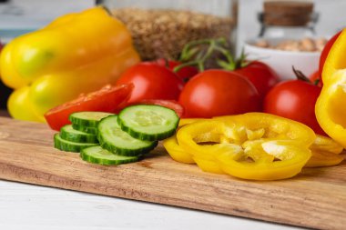 Tahta tahtada sebze kes. Biber, domates ve salatalık.