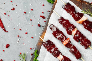 Tahtadaki şişler üzerinde çiğ ciğer kebabı.