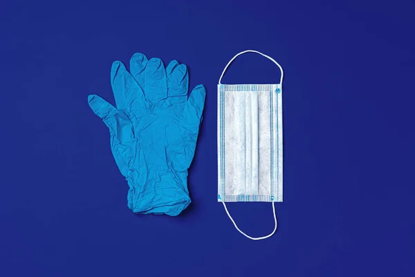 深蓝色背景的医用手套和外科防护面罩 — 图库照片