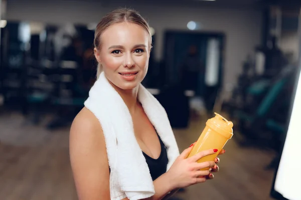 Ελκυστική θετική γυναίκα με πετσέτα και μπουκάλι νερό στο γυμναστήριο — Φωτογραφία Αρχείου