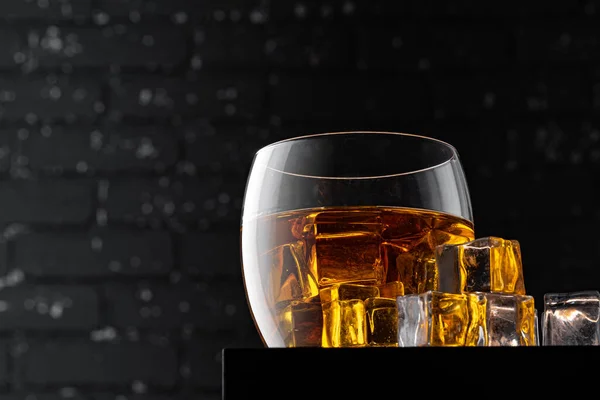 Whisky-Glas gegen dunkelschwarze Grunge-Wand — Stockfoto