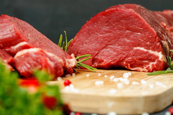 Slice of raw beef fillet on wooden board