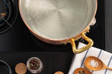 Gaz sobasında kaynar suyla bakır kap.