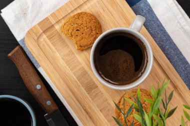 Mutfak masasındaki tahtanın üzerinde bir fincan sıcak kahve.