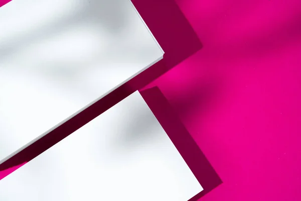 Werbe-Attrappe. Weiße leere Visitenkarten auf leuchtend rosa Hintergrund — Stockfoto