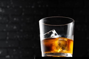Koyu siyah grunge duvarına karşı viski bardağı