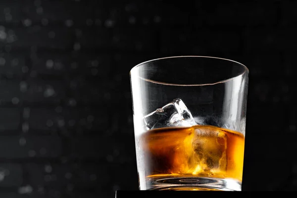 Whisky-Glas gegen dunkelschwarze Grunge-Wand — Stockfoto