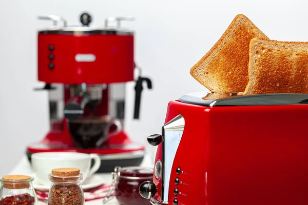 Zwei Toastbrote springen aus rotem Toaster vor weißem Hintergrund — Stockfoto
