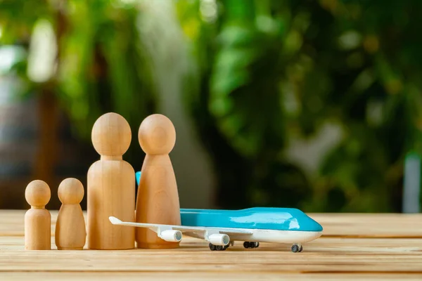 Viajes familiares y concepto de vacaciones. Figuras de madera del avión de la familia y del juguete — Foto de Stock