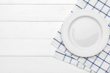 Boş tabak ve havlu ahşap masa arka planında.