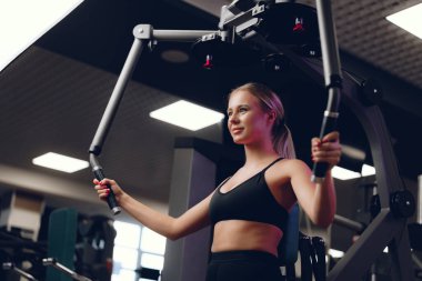 Beyaz tenli sarışın kadın spor salonunda el eğitimi veriyor.