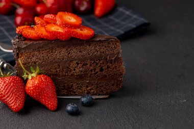 Kesilmiş çilekli bir dilim çikolatalı pasta.