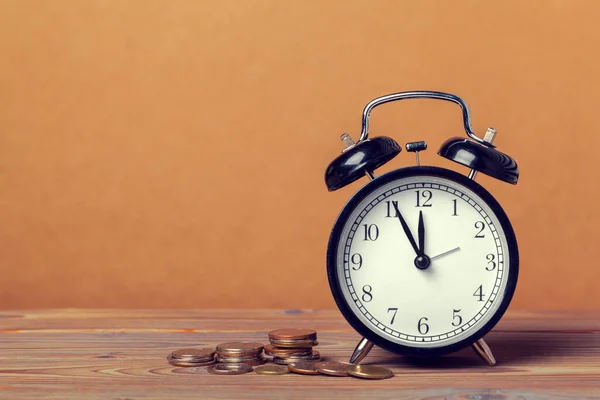 Le temps est argent, horloge de table avec des pièces — Photo