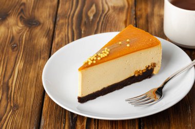 Masadaki beyaz tabakta bir parça peynirli kek