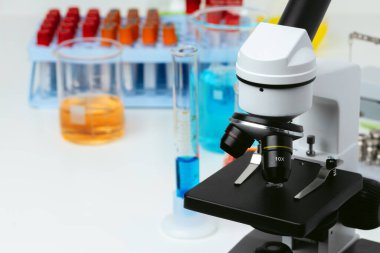 Laboratuvardaki masada mikroskop ve test tüpleri, kapatın.