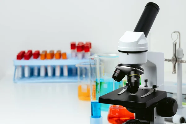 Mikroskop und Reagenzgläser auf dem Tisch im Labor, Nahaufnahme — Stockfoto