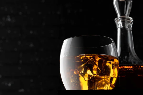 Whisky sklo proti tmavě černé grunge zeď — Stock fotografie