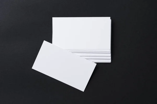 Weiße leere Visitenkarten auf dunkelschwarzem Hintergrund — Stockfoto