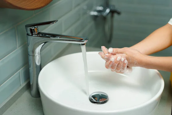 Крупный план женщины, моющей руки в раковине в ванной — стоковое фото
