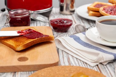 Tost, meyve reçeli ve bıçaklı mutfak masasının fotoğrafı.