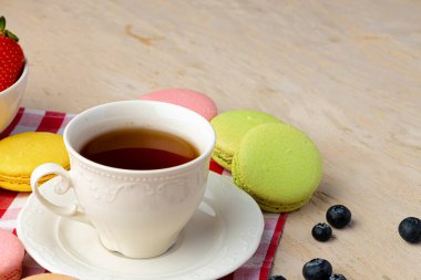 Renkli kurabiyelerle bir fincan kahve yakın.