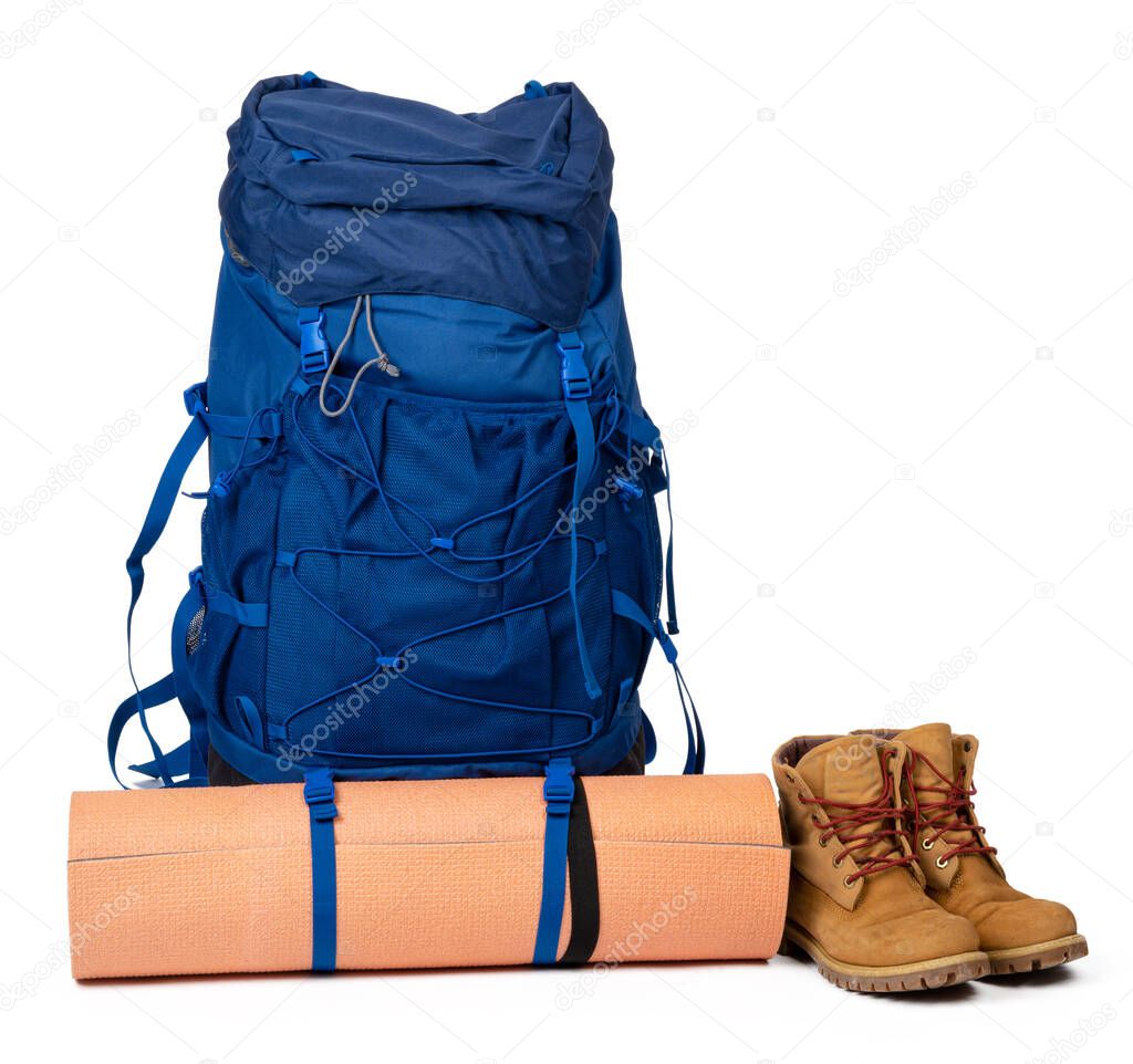 Blue hiking backpack with fitness mat isolated on white