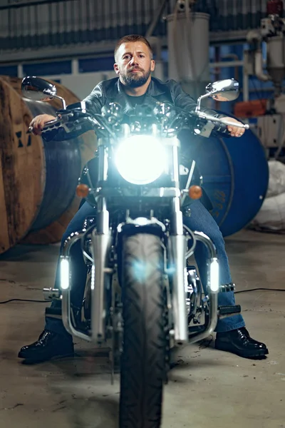 Mann sitzt mit Motorrad in Tiefgarage — Stockfoto