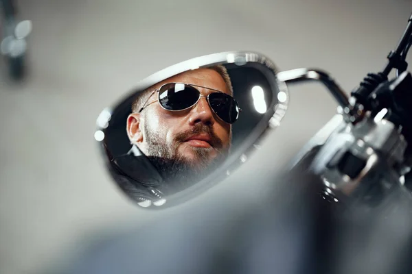 Reflexão no espelho da motocicleta de um homem motorista em óculos de sol — Fotografia de Stock