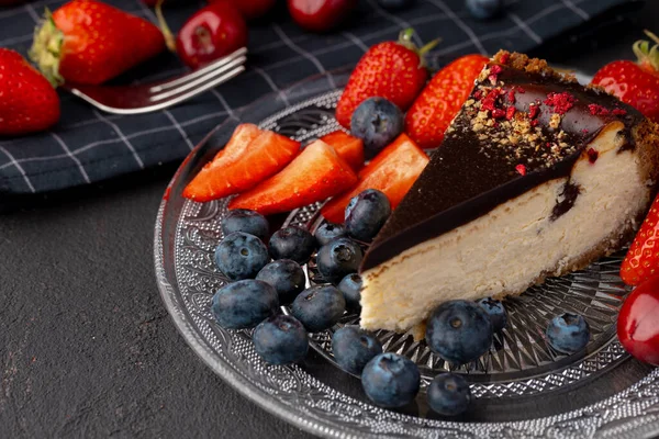 Pedaço de cheesecake com top de chocolate e bagas — Fotografia de Stock