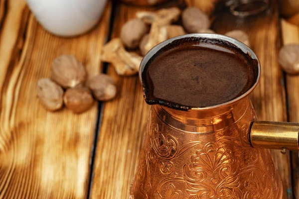 Turk de cobre brilhante com café fabricado em mesa de madeira marrom — Fotografia de Stock