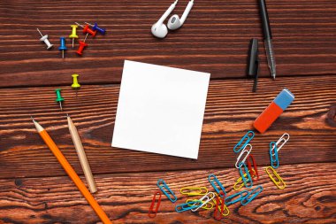 Okul malzemeleri ve ahşap arka planda boş kağıt.