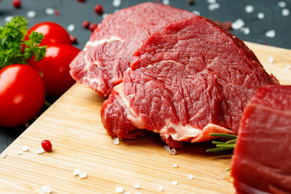 Slice of raw beef fillet on wooden board
