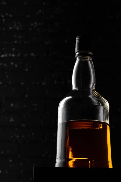 Whisky-Flasche hautnah gegen schwarze Grunge-Wand — Stockfoto