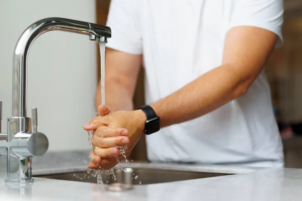 Seorang pria mencuci tangan dengan sabun di wastafel di rumahnya — Stok Foto