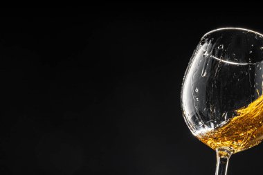 Siyah arka planda bir kadeh şarap, yakın plan.