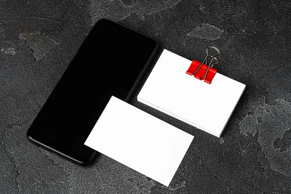 Weiße Visitenkarten vereint mit einer Büroklammer auf schwarzem Hintergrund — Stockfoto