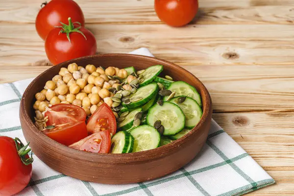 Plato de arcilla de garbanzos y pepinos cortados y tomates. Alimentación saludable — Foto de Stock