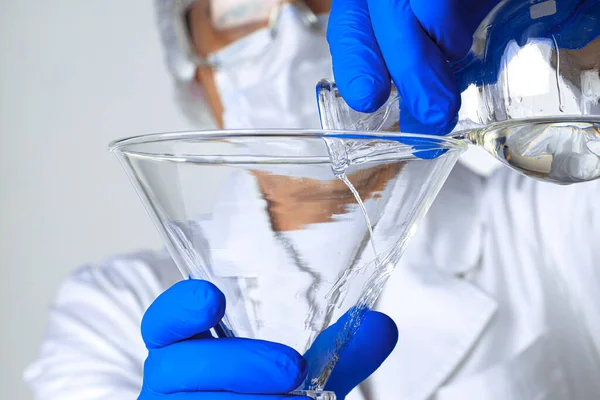 科学者の手分析のための研究室でガラス製品に液体を保持 — ストック写真