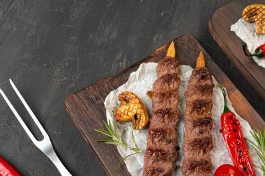 Tahtada servis edilen şişler üzerinde ızgara Lula kebabı.